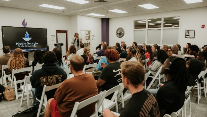 Dr. Kristie Roberts-Lewis speaking to a seated crowd in the CMGS